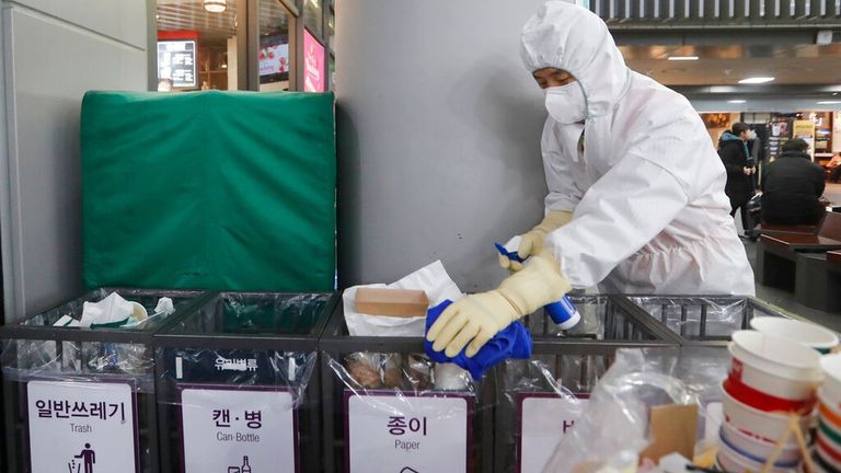 تعقيم سلات القمامة بالكحول والمطهرات للوقاية من كورونا شخصان يرتديان الكمامة للوقاية من كورونا