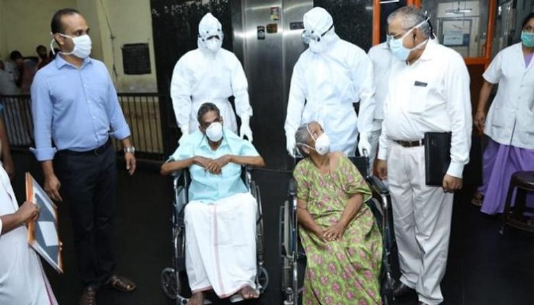 زوجان مسنان في الهند أثناء خروجهما من المشفى
