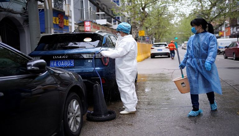 إجراءات تعقيم مستمرة في مدينة ووهان  رجل يسير بدراجة في ميدان بمدينة ووهان