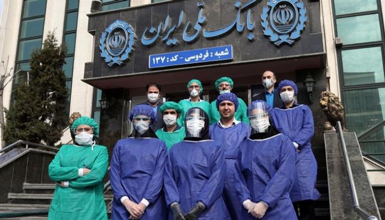 موظفون أمام بنك في طهران - رويترز
