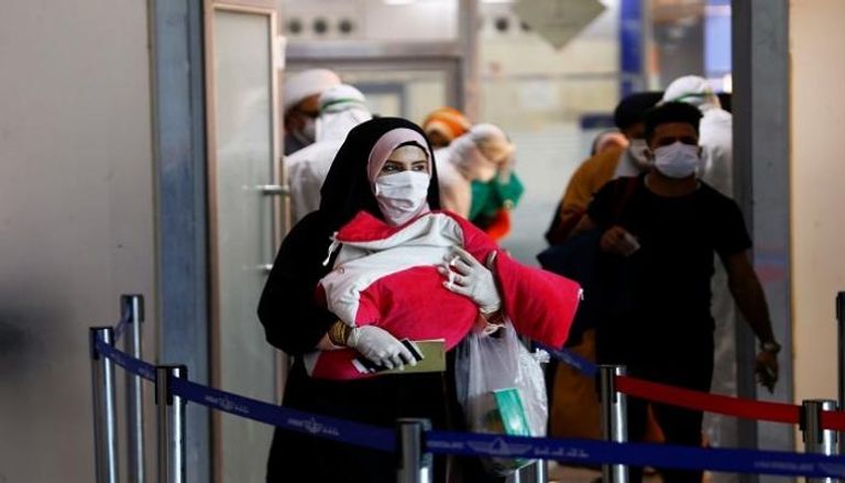 مسافرون يرتدون كمامات في مطار نجف بالعراق