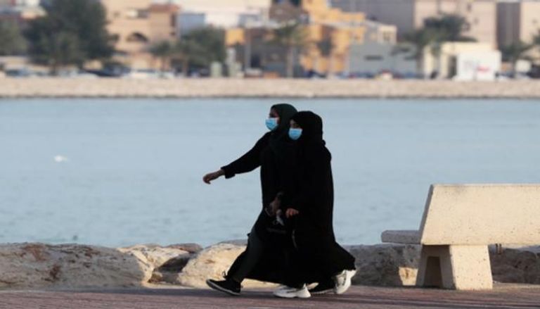 فتاتان ترتديان كمامات في أحد شوارع الكويت