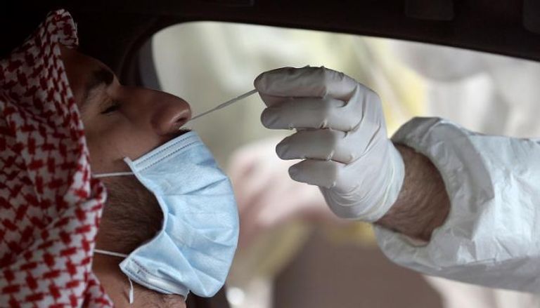 عامل صحي يأخذ مسحة من بحريني للتأكد من عم إصابته بفيروس كورونا