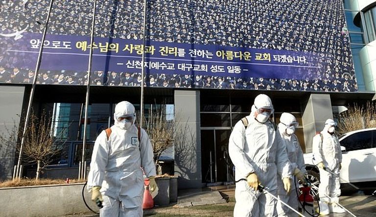 عمال يقوم برش المطهرات أمام كنيسة شينتشونجي