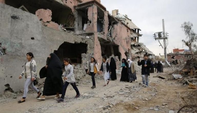 مدنيون أكراد بجوار منازل دمرها القصف التركي في شرناق