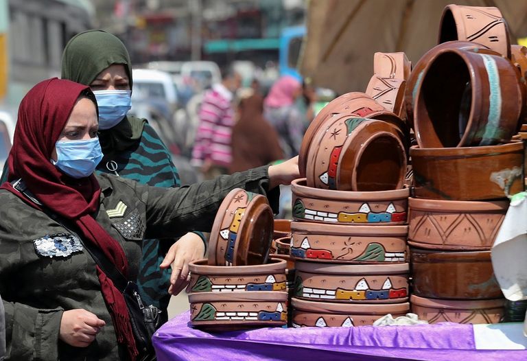 رجل يرتدي كمامة ويخضع لقياس درجة الحرارة