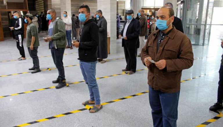 أشخاص يضعون كمامات للوقاية من فيروس كورونا في مصراتة - رويترز