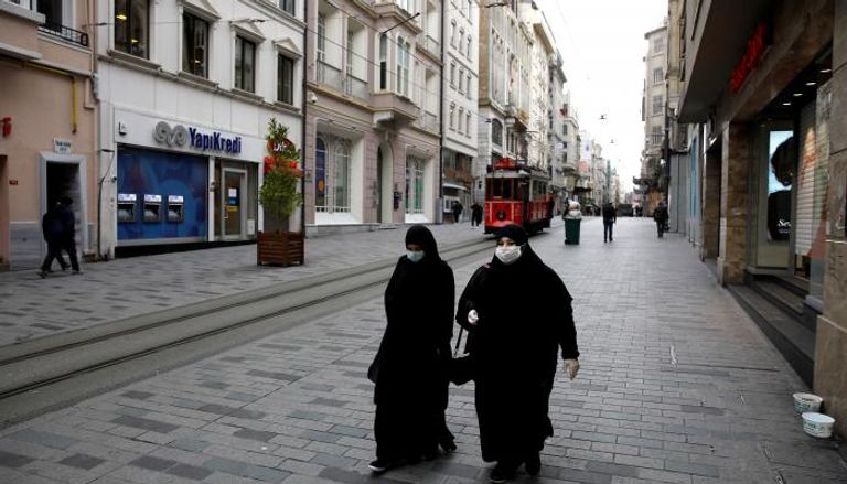 سيدتان ترتديان أقنعة وقفازات واقية للوجه في إسطنبول