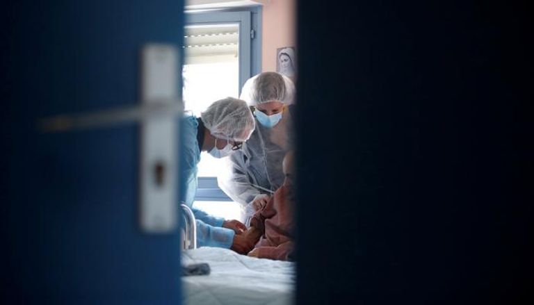 عاملون صحيون يأخذون عينة دم من أحد المواطنين في فرنسا