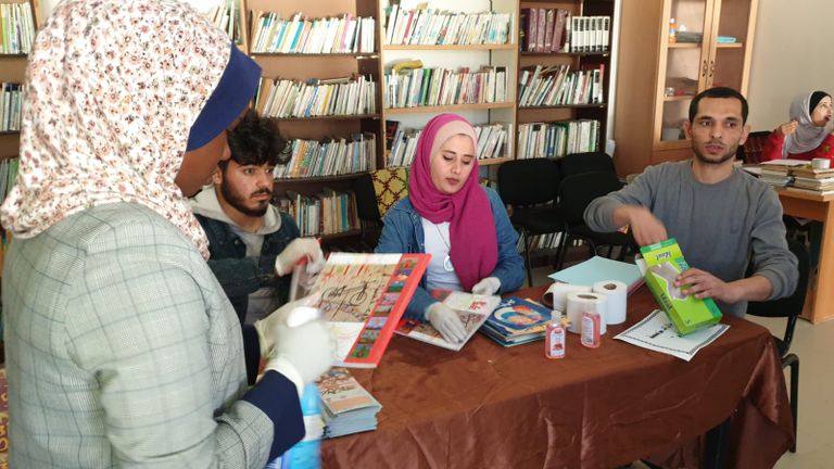 أعضاء المبادرة يوزعون الكتب على الأطفال