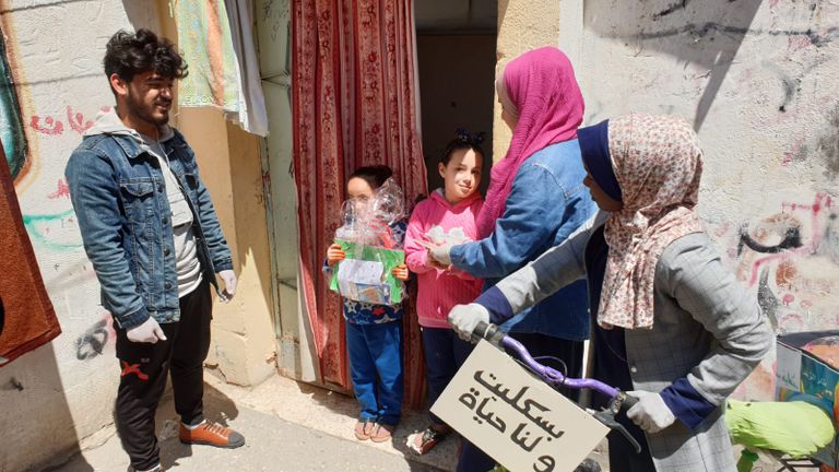 أعضاء المبادرة يوزعون الكتب على الأطفال