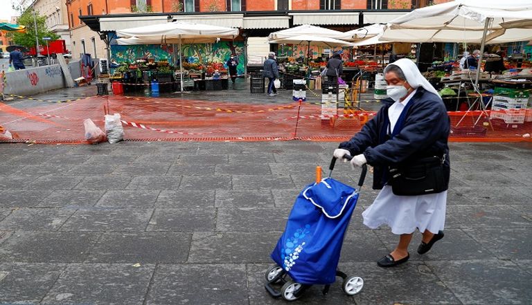 أشخاص يرتدون كمامات للوقاية من عدوى كورونا في إيطاليا