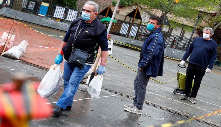 أشخاص يرتدون كمامات للوقاية من عدوى كورونا في إيطاليا