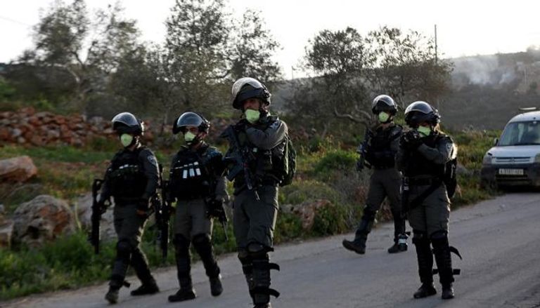 جنود من حرس الحدود الإسرائيلي يرتدون الكمامة