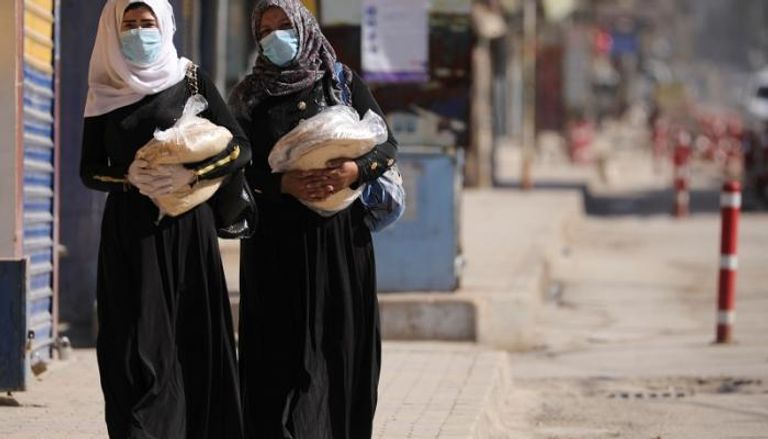سوريتان ترتديان الكمامة الواقية في شارع يخلو من المارة