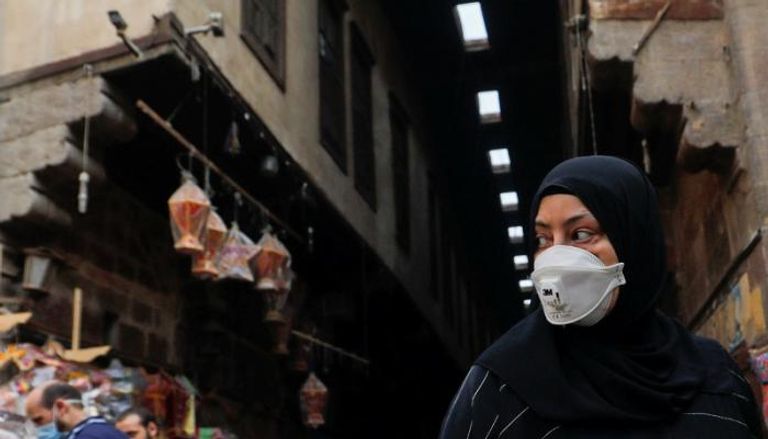 مصرية ترتدي الكمامة في أحد شوارع القاهرة