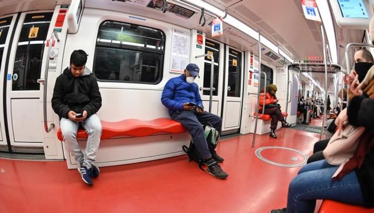 ركاب مترو يضعون الكمامات للوقاية من كورونا