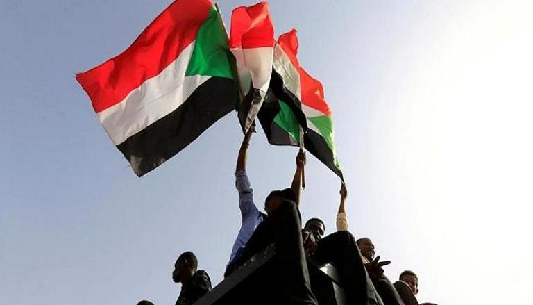 سودانيون يلوحون بعلم بلادهم 