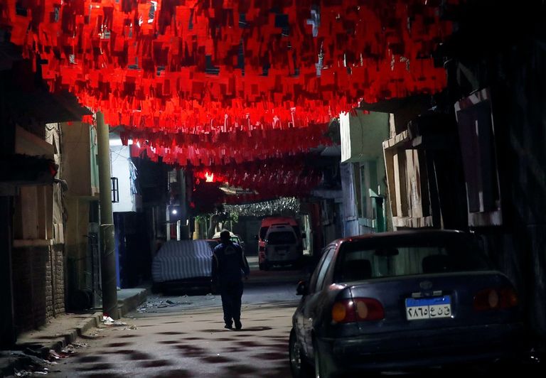 زينة رمضان 2020 في ظل حظر التجوال في مصر والشوارع شبه خالية بسبب فيروس كورونا امرأة ترتدي كمامة في سوق لفوانيس رمضان بمصر