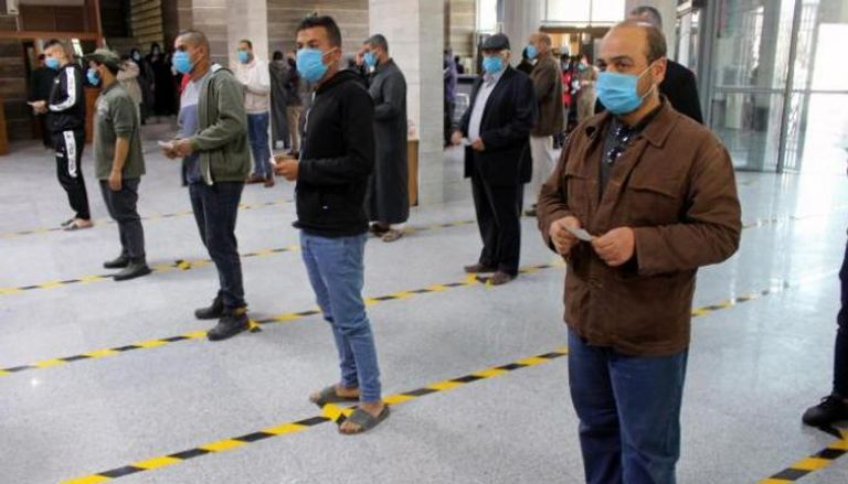 أشخاص يضعون كمامات للوقاية من فيروس كورونا في مصراتة - رويترز