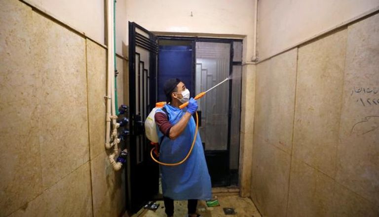 متطوع يتولى تطهير أحد المباني لمواجهة فيروس كورونا