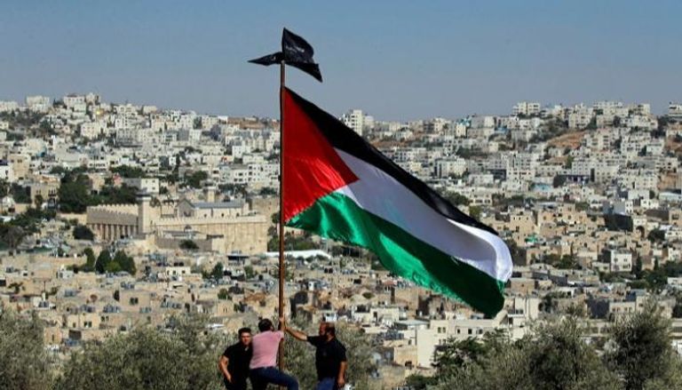 فلسطينيون يرفعون علم بلادهم بالضفة الغربية - أرشيفية