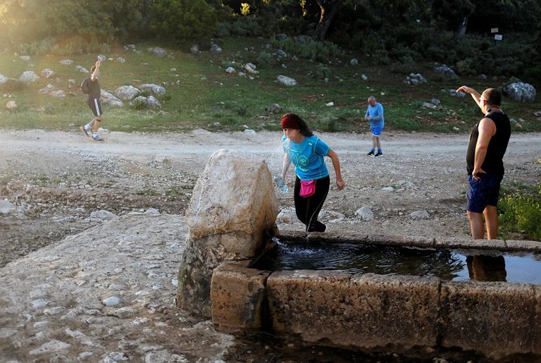 يأخذ الناس استراحة من الجري في نافورة صغيرة، خلال الساعات المسموح بها للتمارين الفردية السماح للإسبان بالتريض لأول مرة منذ 7 أسابيع مع تخفيف إجراءات العزل