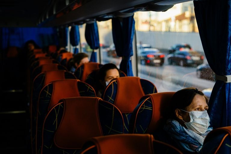 عاملون في مجال الرعاية الطبية في إحدى الحافلات في طريقهم إلى العمل في موسكو روسيا توفر فنادق مجانية لطواقمها الطبية