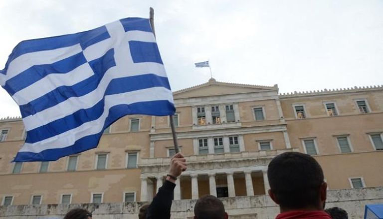 مواطن يرفع علم اليونان