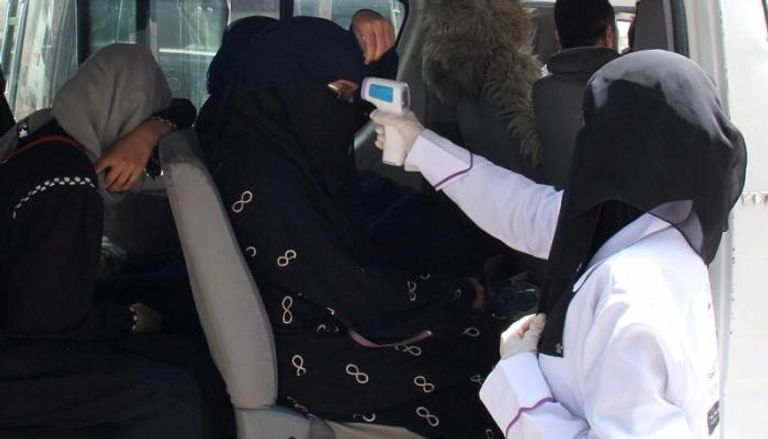 طبيبة يمنية تفحص درجة حرارة ركاب حافلة في اليمن