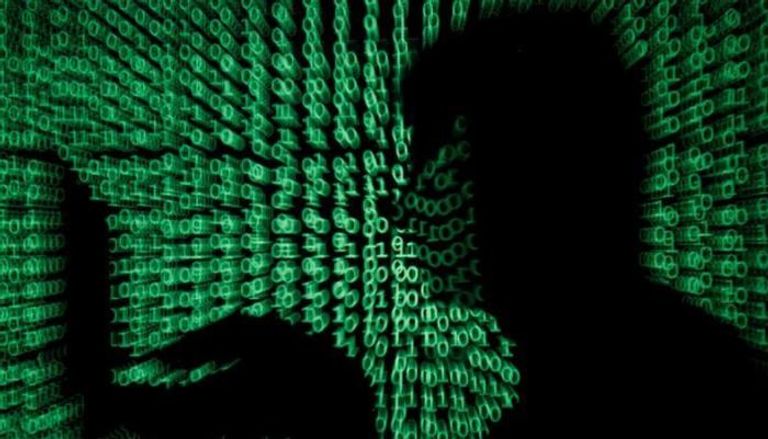 رجل يستخدم كمبيوتر وحوله شفرات إلكترونية صورة توضيحية - رويترز