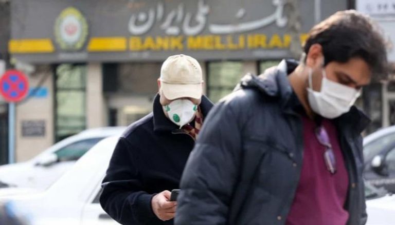 شخصان يرتديان الكمامات في طهران