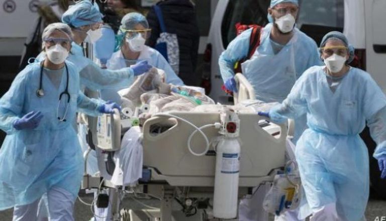 فريق طبي ينقل مصابا بكورونا إلى المستشفى
