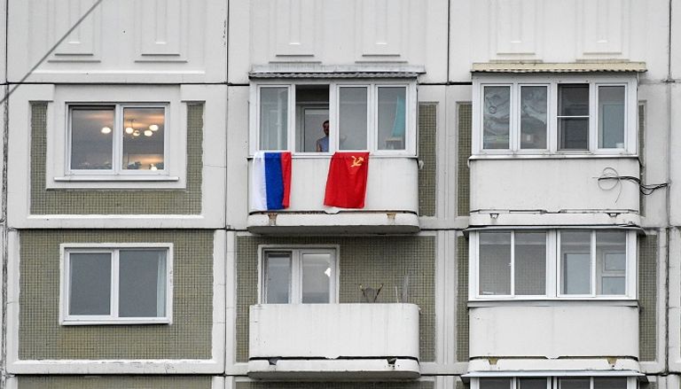 رجل روسي يلوح بعلم بلاده احتفالا بذكرى النصر