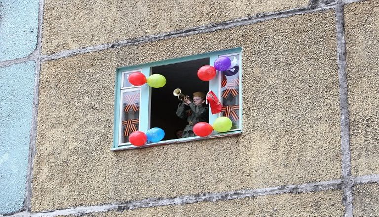 رجل روسي يلوح بعلم بلاده احتفالا بذكرى النصر