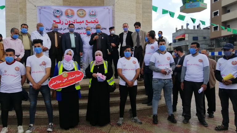 متطوعة تُلبِس صبية كمامة طبية