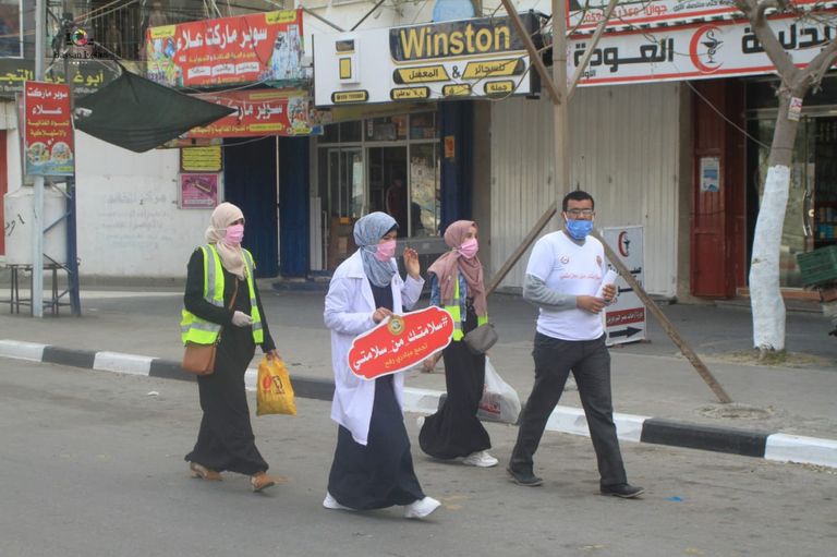 متطوعة تُلبِس صبية كمامة طبية