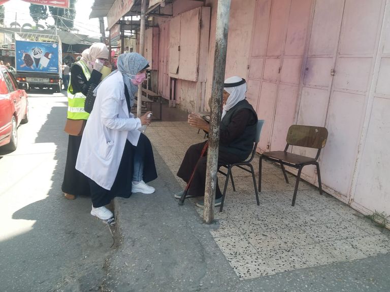 متطوعة تُلبِس صبية كمامة طبية
