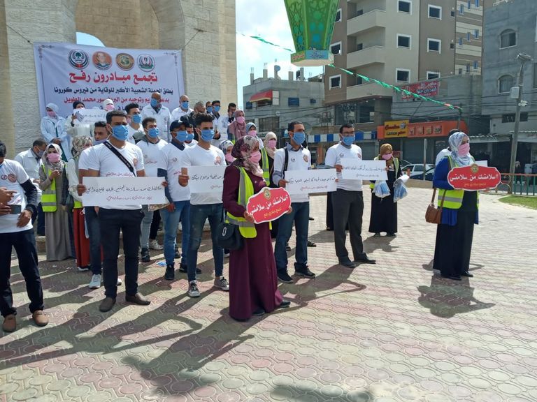 متطوعة تُلبِس صبية كمامة طبية