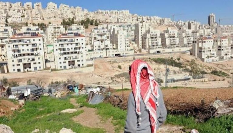 فلسطيني ينظر إلى مستوطنات مقامة بالضفة المحتلة- أرشيفية 