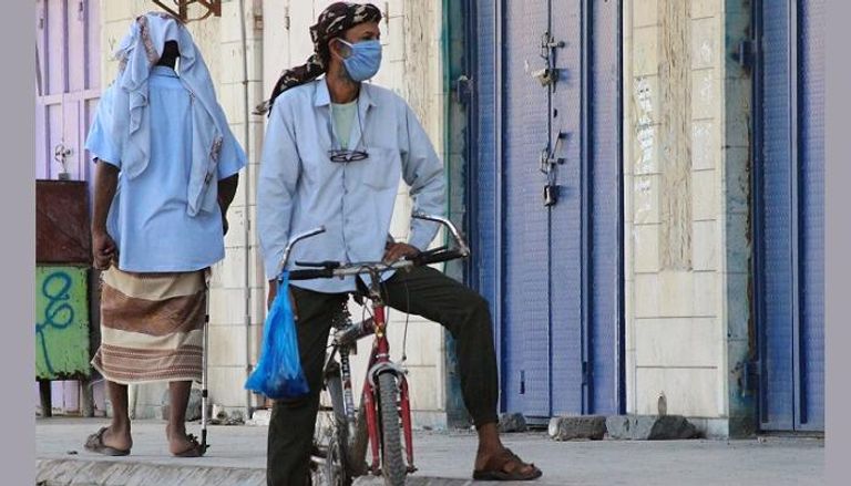 مواطن يمني يرتدي الكمامة الواقية (رويترز)