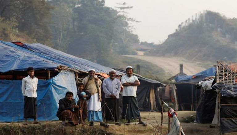 رجال من الروهينجا يقفون بجوار  مخيماتهم في بنجلاديش- أرشيفية