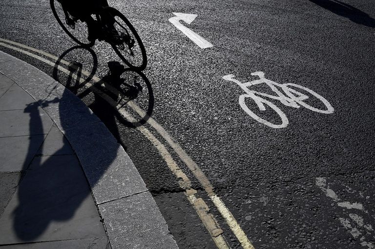 فتاة تقود دراجة بينما ترتدي كمامة في لندن