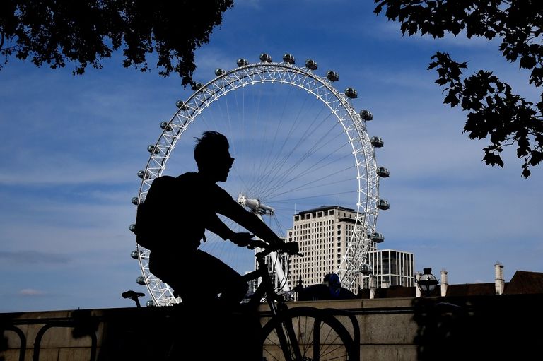 فتاة تقود دراجة بينما ترتدي كمامة في لندن