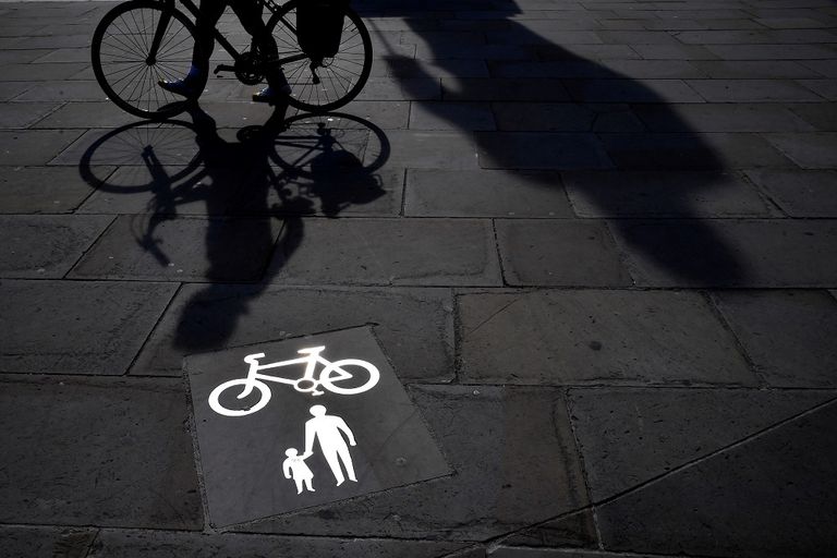 فتاة تقود دراجة بينما ترتدي كمامة في لندن