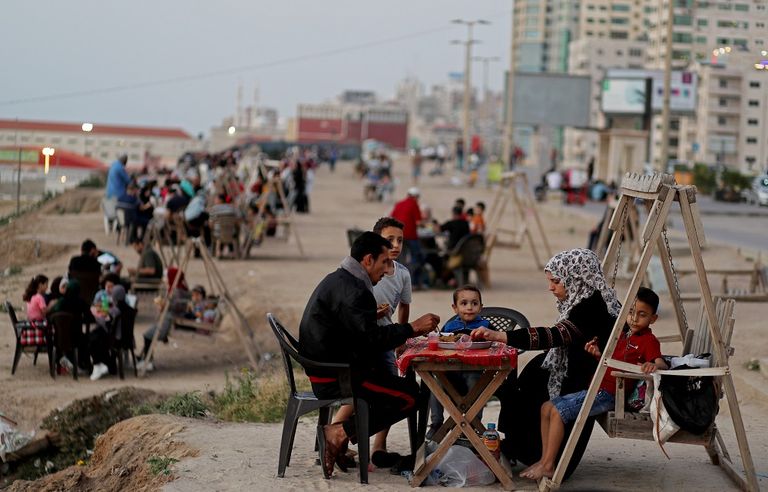 أسرة تستعد لتناول وجبة الإفطار على شاطئ غزة