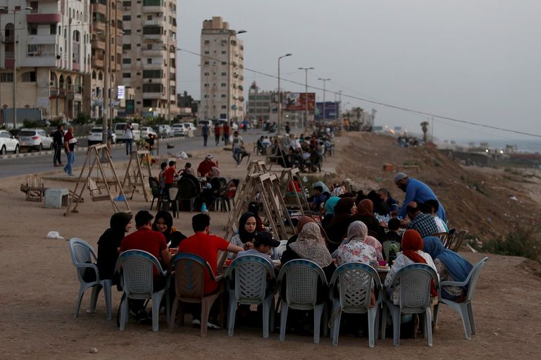 أسرة تستعد لتناول وجبة الإفطار على شاطئ غزة