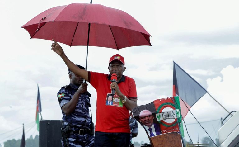 سيدة بوروندية تحمل علما وتضع كمامة