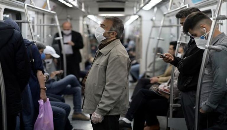 إيرانيون يرتدون كمامات للوقاية من عدوى كورونا في المترو 