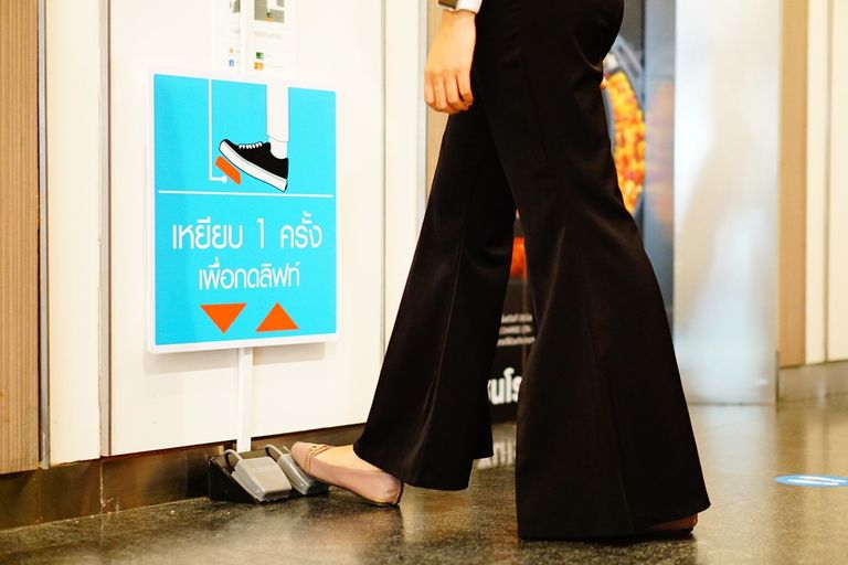 شخص يضع قدمه على دواسة المصعد